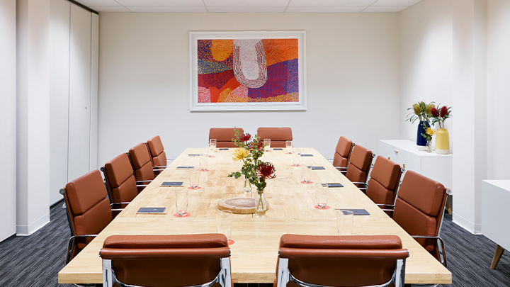 A light hotel lobby space with orange art on the wall